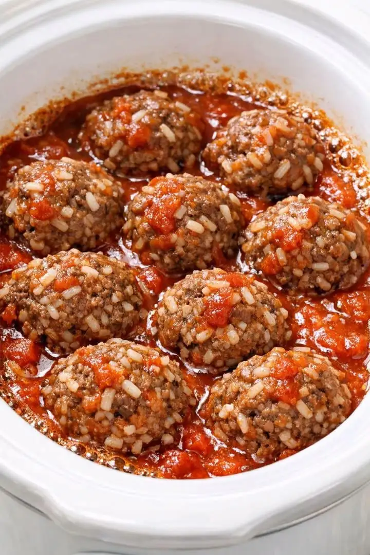 Zarte 4-Zutaten-Stachelschwein-Frikadellen mit sichtbaren Reiskörnern in einer cremigen Tomatensauce direkt aus dem Slow Cooker serviert.